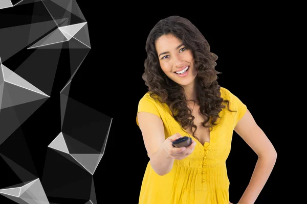 Composite image of smiling curly haired pretty woman changing channel with remote — Stock Photo, Image