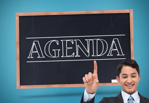 Composite image of smiling asian businessman pointing — Stock Photo, Image