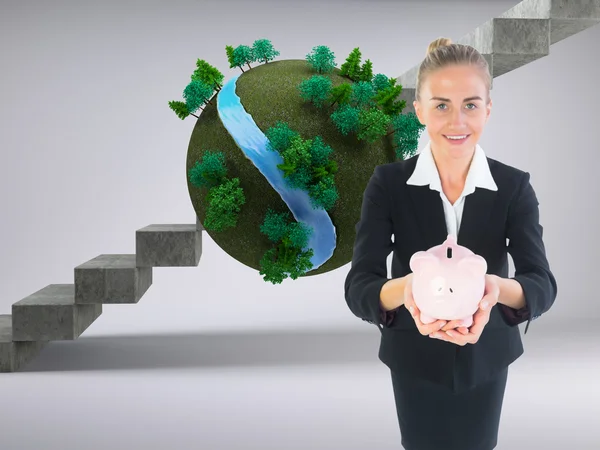 Composite image of businesswoman holding pink piggy bank — Stock Photo, Image