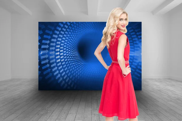 Composite image of smiling blonde standing hands on hips — Stock Photo, Image