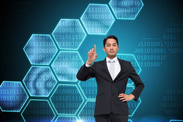 Composite image of unsmiling asian businessman pointing — Stock Photo, Image