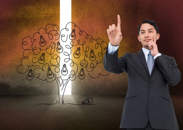 Composite image of thoughtful asian businessman pointing — Stock Photo, Image