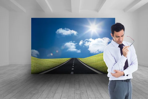 Imagen compuesta de hombre de negocios pensando sosteniendo gafas — Foto de Stock