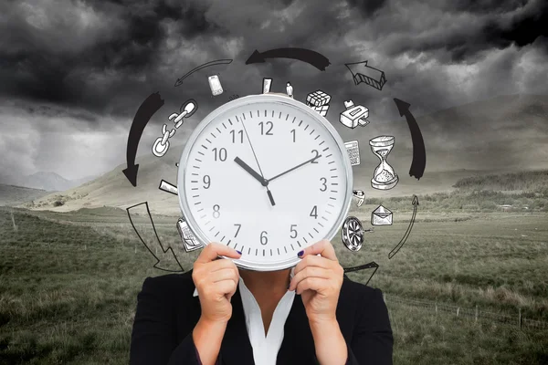 Image composite de femme d'affaires en costume tenant une horloge — Photo