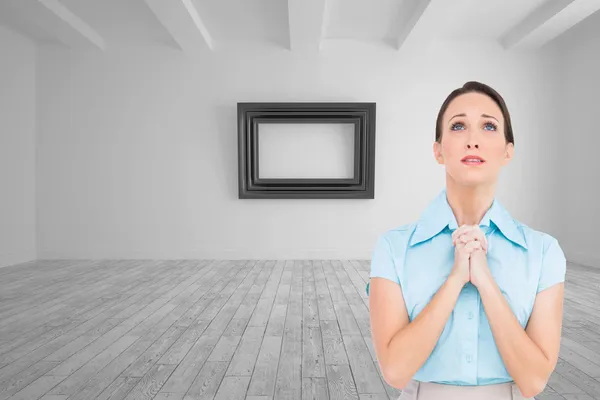 Composite image of troubled young businesswoman praying — Stock Photo, Image