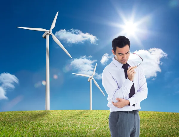 Composite image of thinking businessman holding glasses — Stock Photo, Image