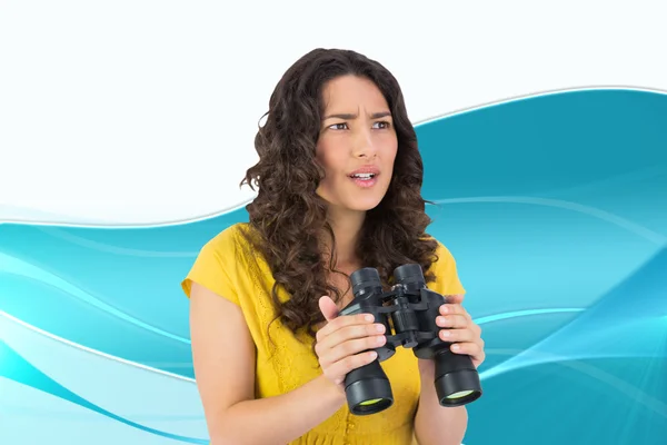 Casual young woman holding binoculars — Stock Photo, Image