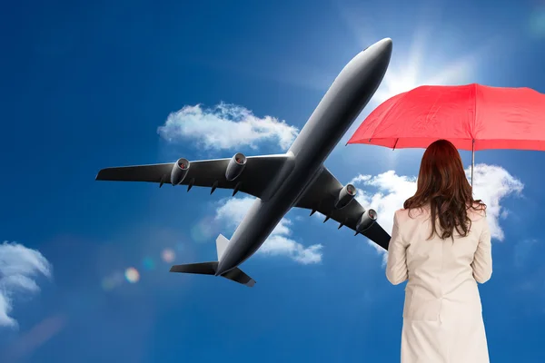 Podnikatelka stojící zpět na fotoaparát drží červený deštník — Stock fotografie