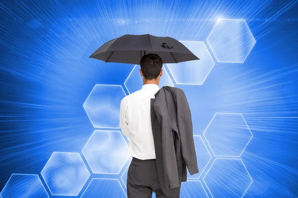 Kompositbild eines Geschäftsmannes, der mit Regenschirm vor der Kamera steht — Stockfoto