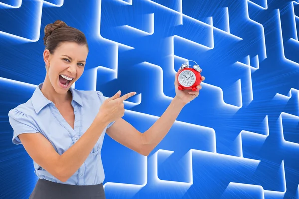 Composite image of businesswoman indicating alarm clock — Stock Photo, Image