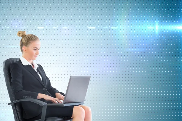 Composite image of businesswoman sitting on swivel chair with laptop — Stock Photo, Image