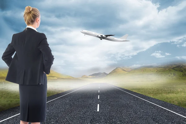 Composite image of businesswoman standing with hands on hips — Stock Photo, Image