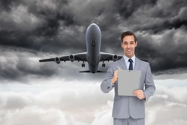 Imagem composta de homem de negócios feliz segurando uma área de transferência — Fotografia de Stock