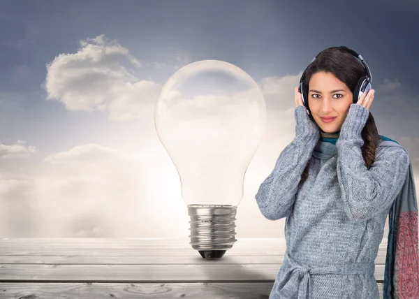 Model wearing winter clothes listening to music — Stock Photo, Image