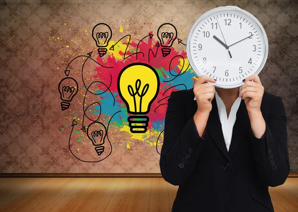 Composite image of businesswoman in suit holding a clock — Stock Photo, Image