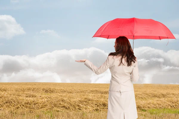 Composite image of businesswoman holding umbrella — Stock Photo, Image