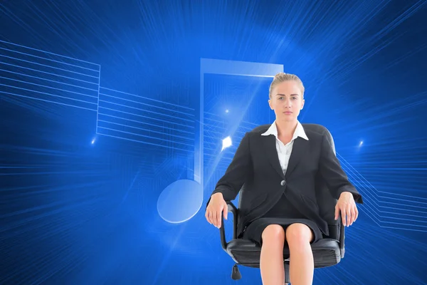 Composite image of businesswoman sitting on swivel chair in black suit — Stock Photo, Image