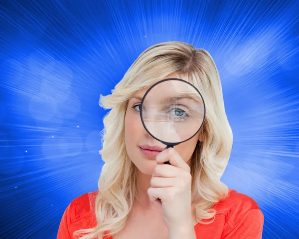 Fair-haired woman looking through a magnifying glass — Stock Photo, Image