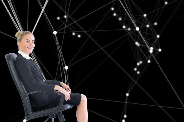 Composite image of businesswoman sitting in swivel chair — Stock Photo, Image