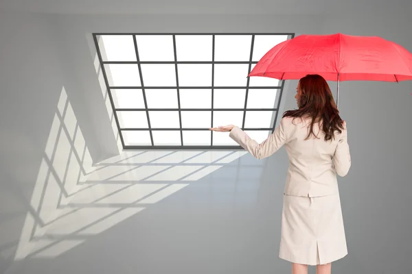 Composite image of businesswoman holding umbrella — Stock Photo, Image