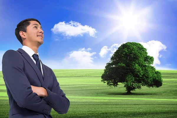 Composite image of smiling asian businessman with arms crossed — Stock Photo, Image