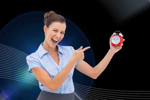 Composite image of businesswoman indicating alarm clock — Stock Photo, Image