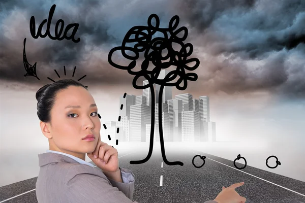 Composite image of thoughtful asian businesswoman pointing — Stock Photo, Image