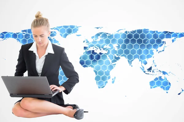 Composite image of businesswoman using laptop — Stock Photo, Image