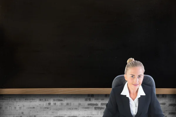 Composite image of businesswoman sitting on swivel chair with la — Stock Photo, Image