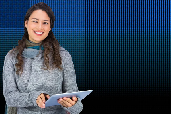 Smiling model wearing winter clothes holding her tablet — Stock Photo, Image