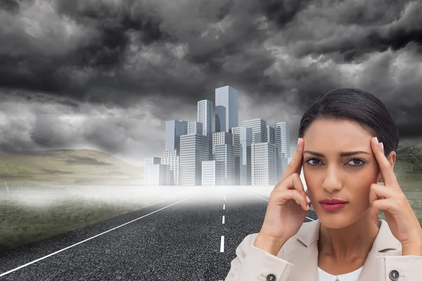 Businesswoman putting her fingers on her temples — Stock Photo, Image