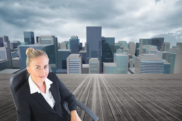 Composite image of businesswoman sitting on swivel chair with laptop — Stock Photo, Image