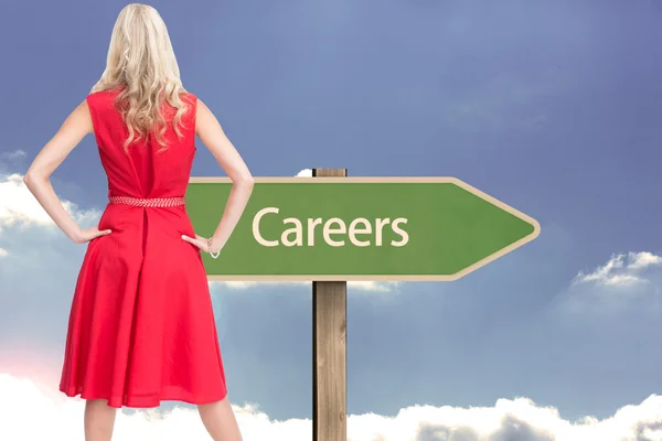 Composite image of elegant blonde standing hands on hips — Stock Photo, Image