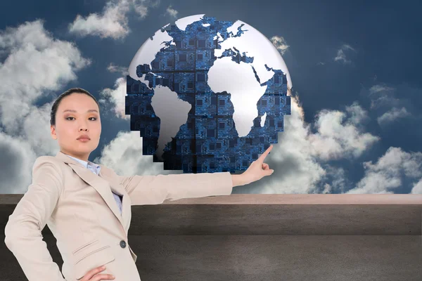 Composite image of unsmiling asian businesswoman pointing — Stock Photo, Image