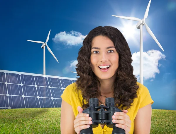 Casual young woman holding binoculars — Stock Photo, Image