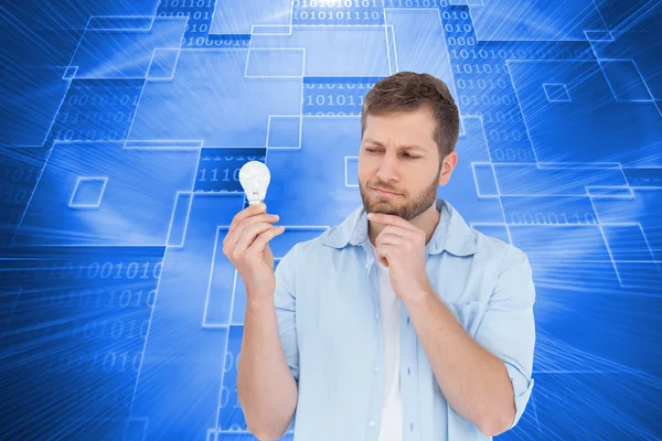 Sceptical model holding a bulb — Stock Photo, Image