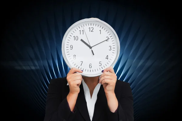 Composite image of businesswoman in suit holding a clock — Stock Photo, Image