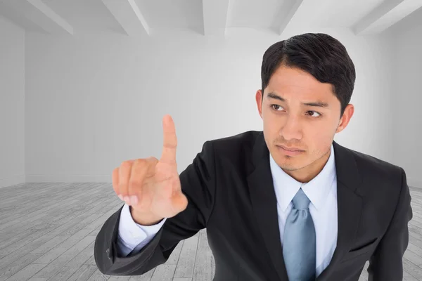 Composite image of unsmiling asian businessman pointing — Stock Photo, Image