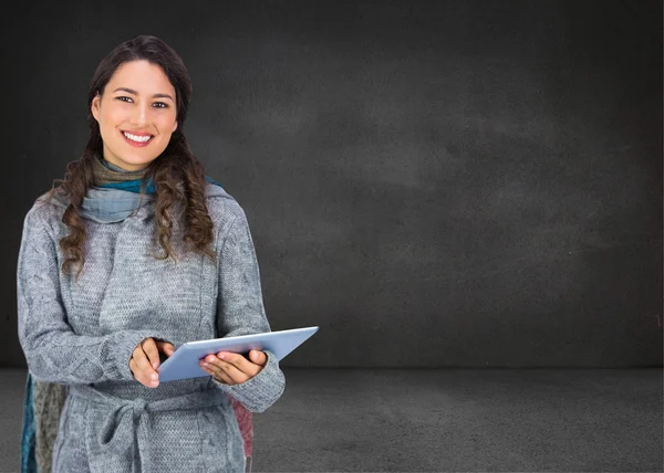 Композитное изображение улыбающейся модели в зимней одежде, держащей планшет — стоковое фото