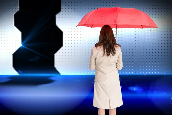 Image composite de femme d'affaires debout à l'arrière de la caméra tenant parapluie rouge — Photo