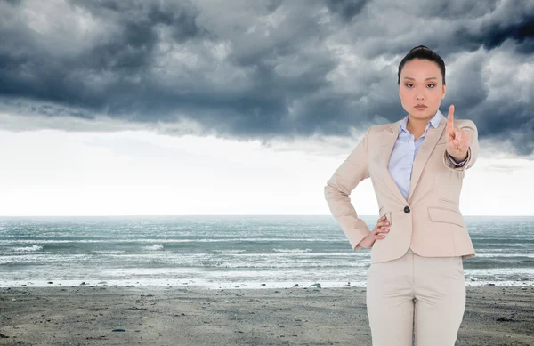 Samengestelde afbeelding van kijkende Aziatische zakenvrouw wijzen — Stockfoto