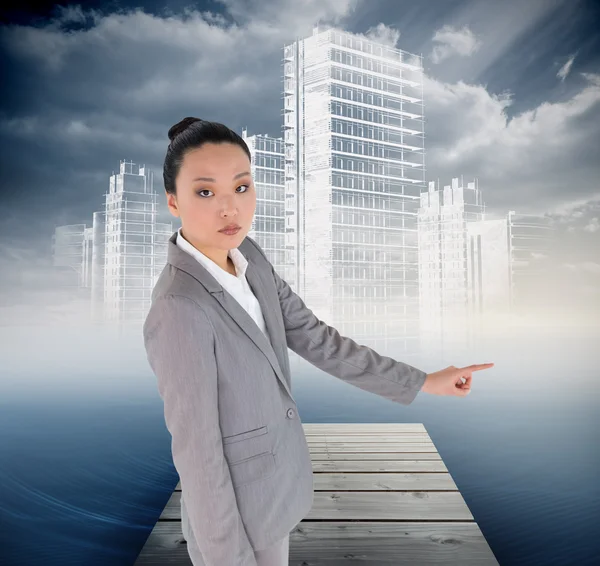 Unsmiling asian businesswoman pointing — Stock Photo, Image