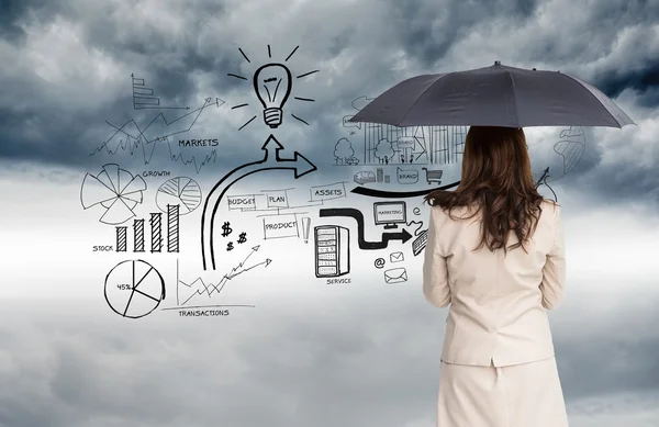 Composite image of rear view of classy businesswoman holding umbrella — Stock Photo, Image