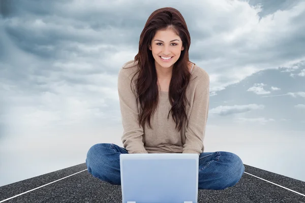 Imagem composta de mulher sentada na cama com o laptop em f — Fotografia de Stock