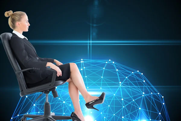 Samengestelde afbeelding van zakenvrouw zittend op een bureaustoel in zwart pak — Stockfoto