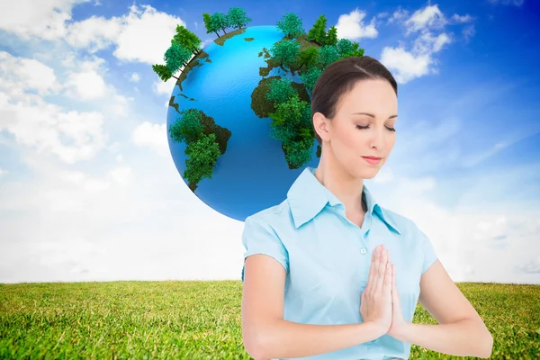 Composite image of peaceful young businesswoman praying — Stock Photo, Image