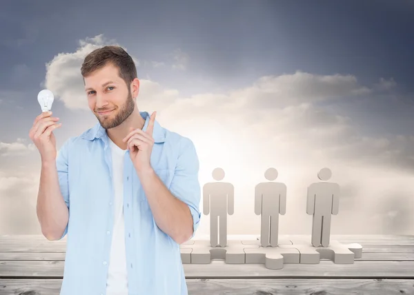 Charming model holding a bulb in right hand — Stock Photo, Image