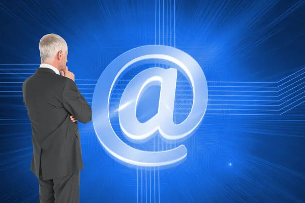 Composite image of thoughtful businessman standing back to camera — Stock Photo, Image