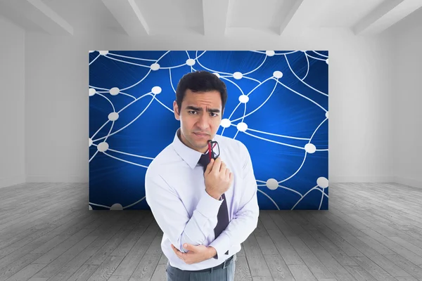 Composite image of thinking businessman holding glasses — Stock Photo, Image
