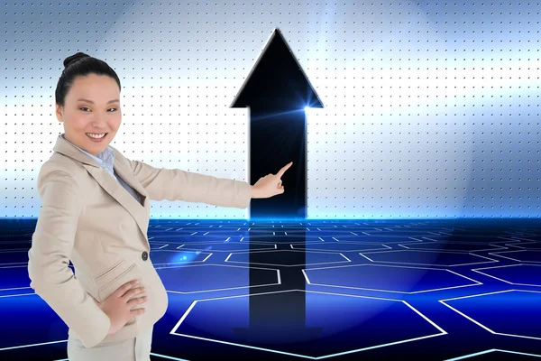 Composite image of smiling asian businesswoman pointing — Stock Photo, Image